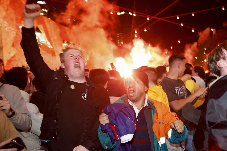 Australian soccer fans celebrate a goal scored as they watch the World Cup group D soccer match between Australia and Denmark, at the Al Janoub Stadium in Al Wakrah, Qatar, at Federation Square in Melbourne, Australia, in the early hours of Thursday, Dec. 1, 2022. Australia will play Argentina in a round of 16 match on Saturday, Dec. 3. (Con Chronis/AAP Image via AP)