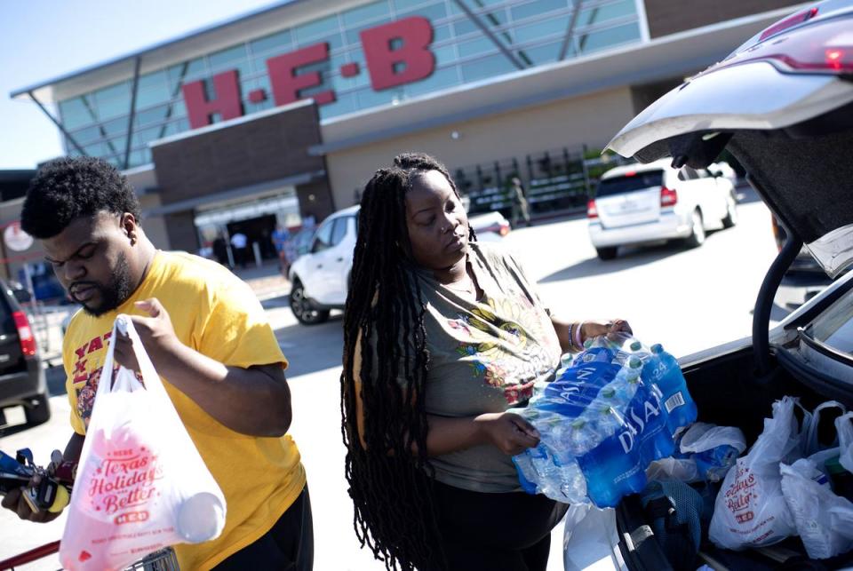 Eboni Davis and her boyfriend Jesse Holloway load water into their car outside an H-E-B grocery store in Houston on Nov. 28, 2022.