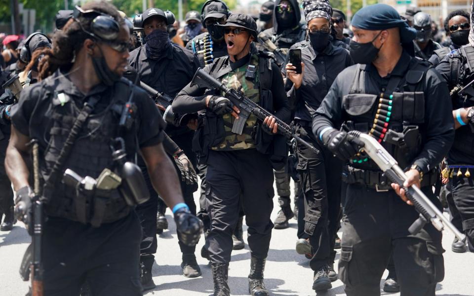 Grand Master Jay, center, leads his followers on a march during an armed rally in Louisville - Reuters