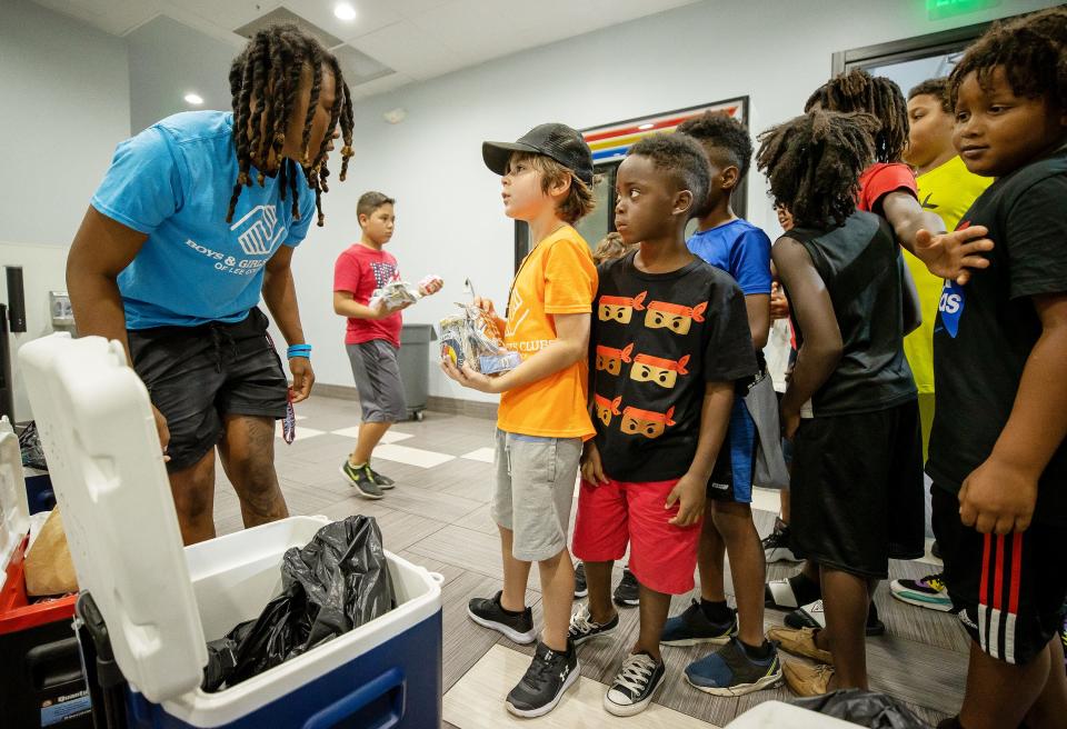 Keri Jewett-Giles serves lunch to Trystin Hill, 9, Kahari Emerson, 6, and others recently at the new Boys and Girls Club on Park Meadows Drive in Fort Myers. Jewett-Giles is the clubÕs director. Jewett-Giles was a star basketball player at Dunbar High School, FGCU and played professionally. 
