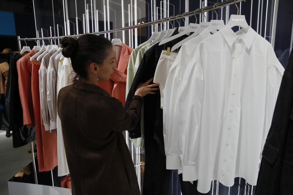 Una mujer mira algunos diseños de la marca Fenty de Rihanna, la primera mujer negra en la historia al frente de una marca de lujo parisina, develados en una tienda pop-up en París el miércoles 22 de mayo del 2019. (AP Foto/Francois Mori)