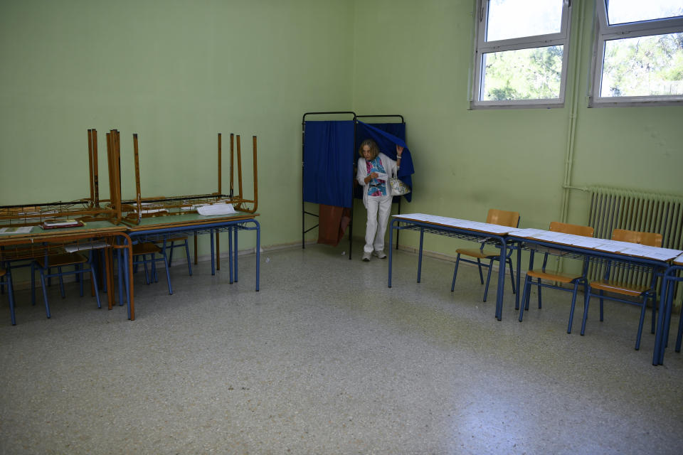 A woman walks out of a booth at a voting center during municipal elections, in Cholargos suburb, Athens, Greece, Sunday, Oct. 15, 2023. The country's two largest cities, and 6 of its 13 regions, are at play in Sunday's runoffs, with low turnout expected again. (AP Photo/Michael Varaklas)