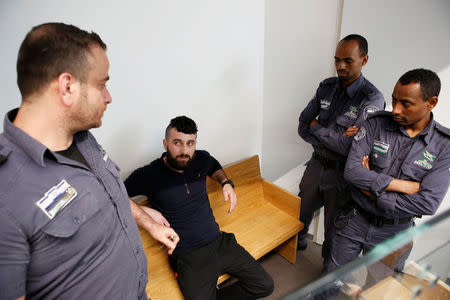 Mohammed Harouf, a Palestinian who pleaded guilty to the murder of a pregnant Jewish settler, sits in court accompanied by Israeli Prison Authority guards, in Tel Aviv, Israel February 4, 2018. REUTERS/Nir Elias