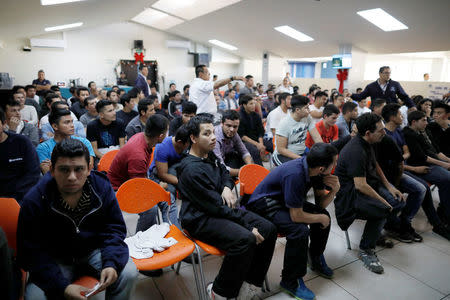 Deportees wait to be process at an immigration facility after a flight carrying illegal immigrants from the U.S. arrived in San Salvador, El Salvador, January 11, 2018. Picture taken January 11, 2018. REUTERS/Jose Cabezas