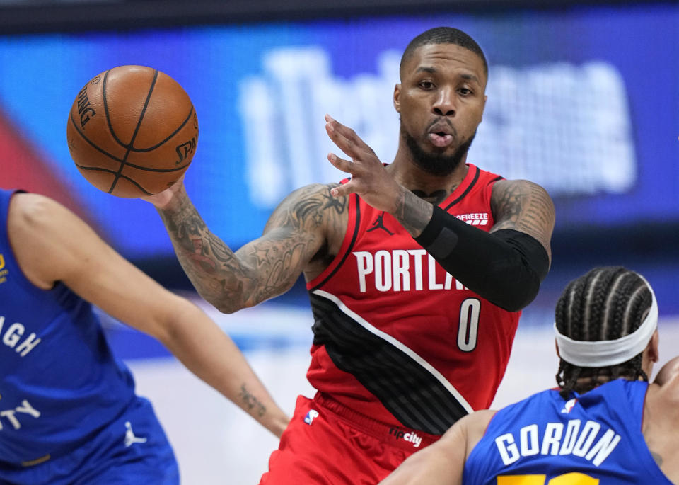 Portland Trail Blazers guard Damian Lillard (0) passes the ball against the Denver Nuggets during the second half of Game 1 of a first-round NBA basketball playoff series Saturday, May 22, 2021, in Denver. (AP Photo/Jack Dempsey)