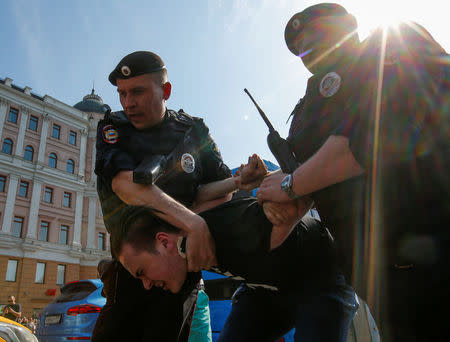 Policemen detain an opposition supporter during a protest ahead of President Vladimir Putin's inauguration ceremony, Moscow, Russia May 5, 2018. REUTERS/Sergei Karpukhin