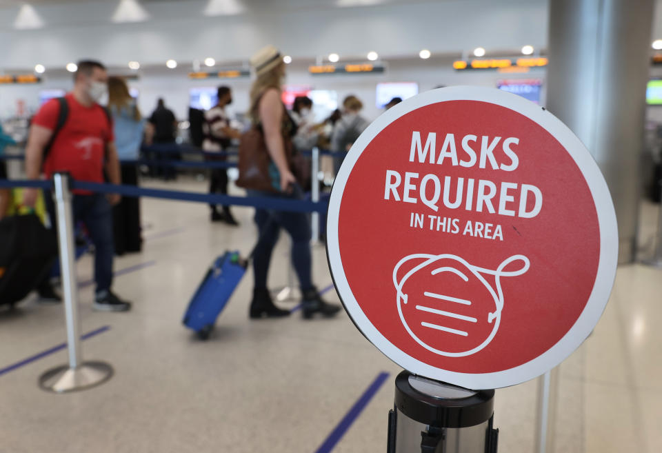 MIAMI, FLORIDA - FEBRUARY 01: A sign reading, 'masks required in this area,' is seen as travelers prepare to check-in for their Delta Airlines flight at the Miami International Airport on February 01, 2021 in Miami, Florida. An executive order signed by U.S. President Joe Biden last week mandates mask-wearing on federal property and on public transportation as part of his plan to combat the coronavirus (COVID-19) pandemic. (Photo by Joe Raedle/Getty Images)