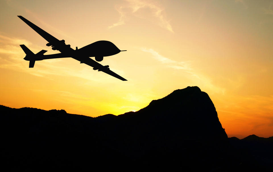 A military drone with the sun in the background