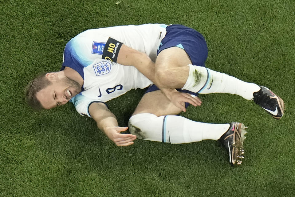 England's Harry Kane grimaces in pain after a tackle by Iran's Morteza Pouraliganji during the World Cup group B soccer match between England and Iran at the Khalifa International Stadium in in Doha, Qatar, Monday, Nov. 21, 2022. (AP Photo/Hassan Ammar)