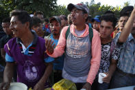 A Honduran migrant stands in line for breakfast at a temporary shelter in Tecun Uman, Guatemala in the border with Mexico, Sunday, Jan. 19, 2020. Mexican authorities have closed a border entry point in southern Mexico after thousands of Central American migrants tried to push across a bridge between Mexico and Guatemala. (AP Photo/Moises Castillo)