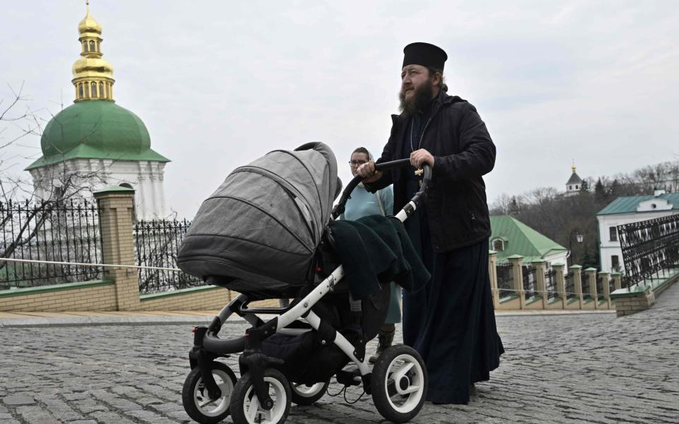 A priest pushes a baby carriage as he walks at Kyiv-Pechersk Lavra, also known as the Kyiv Monastery of the Caves, a historical Eastern Orthodox Christian monastery in Kyiv, on March 24, 2023. - The aurthorities have ordered the monks to leave by March 29, 2023 the Kyiv-Pechersk Lavra, which was previously affiliated with the Russian Orthodox Church and has a crucial role in Eastern Orthodoxy but the monks say there is "no legal foundation" for an expulsion order from the government and say they plan to stay as long as possible. (Photo by Genya SAVILOV / AFP) (Photo by GENYA SAVILOV/AFP via Getty Images) - GENYA SAVILOV/AFP via Getty Images