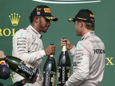 Formula One F1 - U.S. Grand Prix - Circuit of the Americas, Austin, Texas, U.S., 23/10/16. Mercedes' Lewis Hamilton of Britain celebrates his victory with second placed finisher and teammate Nico Rosberg of Germany (R) during the victory ceremony. REUTERS/Adrees Latif