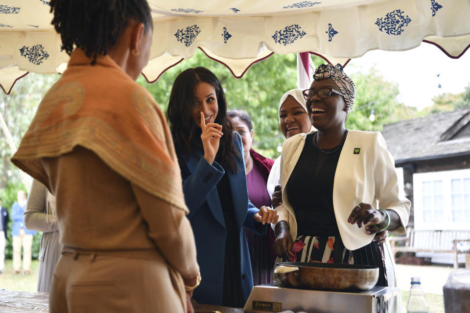 Meghan, the Duchess of Sussex, gestures to her mother Doria Ragland, foreground, as she welcomes women involved with the cookbook "Together" during a reception at Kensington Palace, in London, Thursday Sept. 20, 2018. The Duchess was joined by her mother and husband Prince Harry for the launch of a cookbook aimed at raising money for victims of the Grenfell fire. (Ben Stansall/Pool Photo via AP)