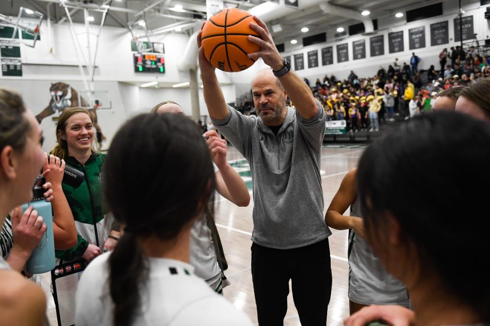 Fossil Ridge head coach Jamie Menefee raises a ball in a post-game huddle after a girls high school basketball game against Fort Collins at Fossil Ridge High School on Tuesday, Jan. 31, 2023 in Fort Collins, Colo.