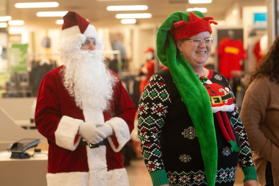 Getting into the festive spirit, Advisors Excel facilities manager Robin Boudreau smiles alongside Santa as students from Topeka Public Schools arrive for a shopping day at Kohl's.