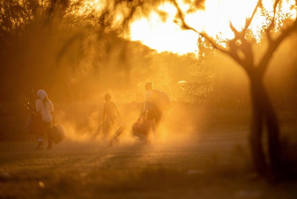 Immigrants walk towards the Rio Grande to cross into Del Rio, Texas, from Ciudad Acuna, Mexico.