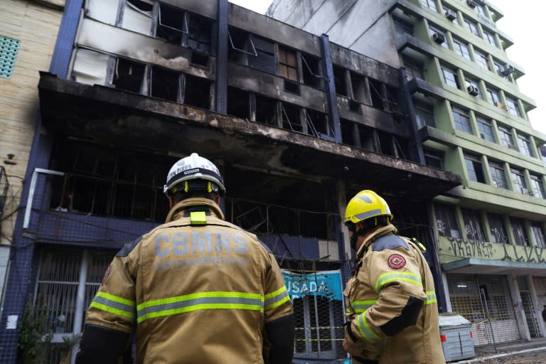 Firefighters work at the site where a homeless shelter caught fire, killing at least 10 people, in Porto Alegre, Brazil (SILVIO AVILA)