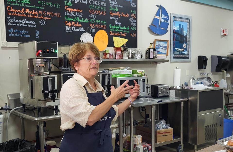 Island Grind co-owner Patty Bain socializes with patrons on Tuesday, Aug. 1, 2023, from behind the coffee shop counter.