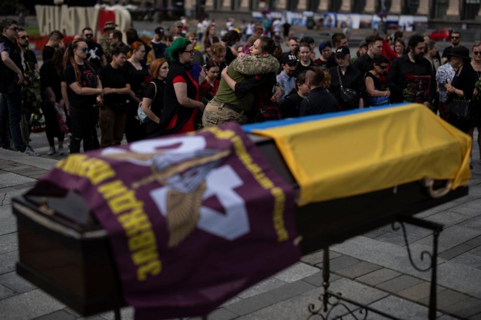 Friends hug each other at Daira Filipova’s funeral in Kyiv (AP)