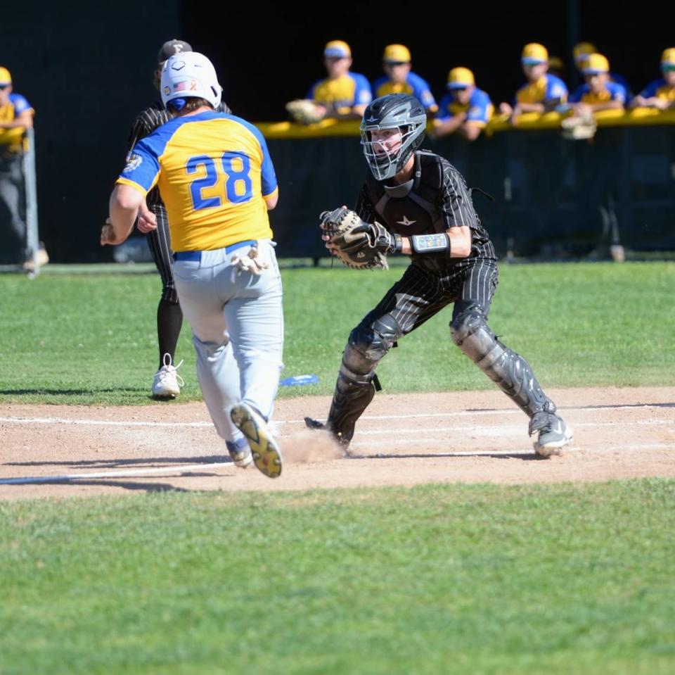 Enochs catcher Caden Reeve tags out Turlock’s Owen Miller at home plate during a CCAL matchup with Turlock at Enochs High School in Modesto, Calif. on Friday, April 19, 2024.