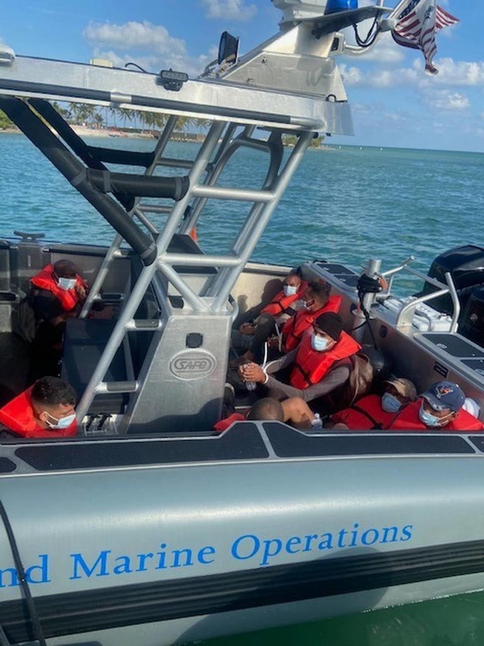 A group of Cuban men who were caught by Border Patrol agents after they landed in the Florida Keys Friday, April 9, 2021, sit handcuffed in the back of a U.S. Customs and Border Protection Air and Marine Operations boat.