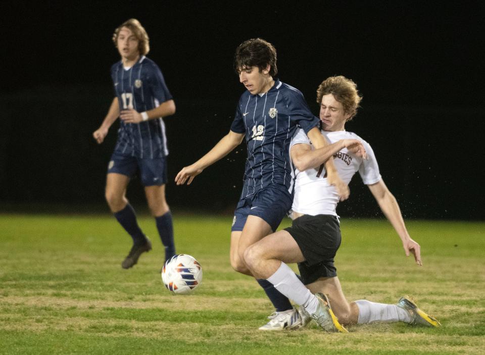 Gulf Breeze High's Gavin Gailey (No. 12) battles Tate High's Michael Christenson (No. 11) for possession near mid-field during the opening half of the District 1-6A Boys' Soccer finals on Wednesday, Feb. 1, 2023. 