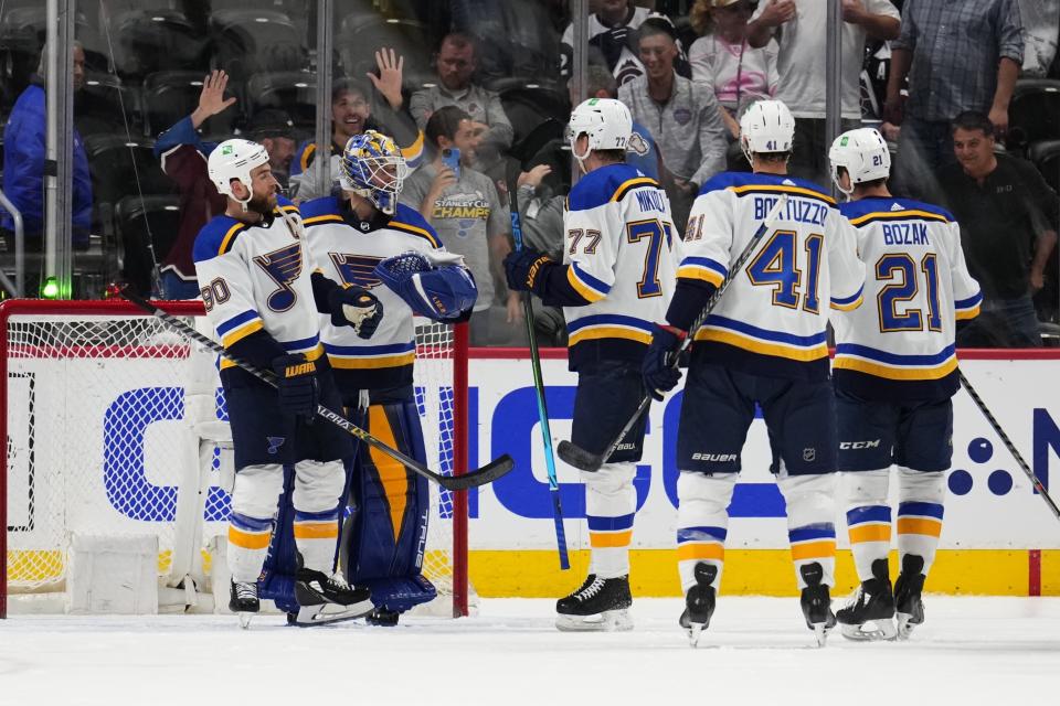 St. Louis Blues center Ryan O'Reilly (90), goaltender Jordan Binnington (50) and teammates celebrate a 4-1 win against the Colorado Avalanche in Game 2 of an NHL hockey Stanley Cup second-round playoff series Thursday, May 19, 2022, in Denver. (AP Photo/Jack Dempsey)