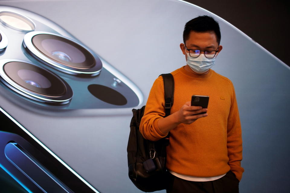 A man wears a face mask while waiting at an Apple Store before Apple's 5G new iPhone 12 go on sale, as the coronavirus disease (COVID-19) outbreak continues in Shanghai China October 23, 2020. REUTERS/Aly Song - RC20OJ9HL7R3