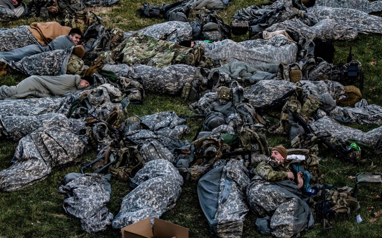 Guardsmen rest on the grass of the Capitol - Samuel Corum/Shutterstock