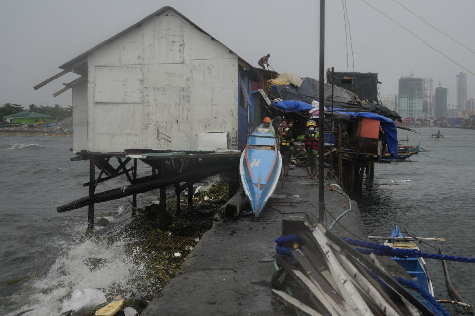 A resident secures the roof of his house at the seaside slum district of Tondo while Typhoon Noru approaches Manila, Philippines, Sunday, Sept. 25, 2022. The powerful typhoon shifted and abruptly gained strength in an "explosive intensification" Sunday as it blew closer to the northeastern Philippines, prompting evacuations from high-risk villages and even the capital, which could be sideswiped by the storm, officials said. (AP Photo/Aaron Favila)