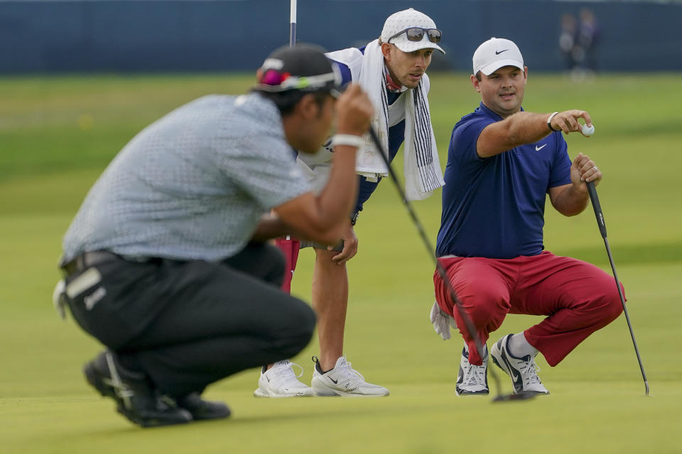 Patrick Reed, of the United States, right, lines up a putt during the first round of the US Open Golf Championship, Thursday, Sept. 17, 2020, in Mamaroneck, N.Y. (AP Photo/John Minchillo)