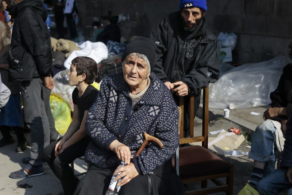 Ethnic Armenians from Nagorno-Karabakh sit next to their belongings near a tent camp after arriving to Armenia's Goris in Syunik region, Armenia, on Saturday, Sept. 30, 2023. Armenian officials say that by Friday evening over 97,700 people had left Nagorno-Karabakh. The region's population was around 120,000 before the exodus began. (AP Photo/Vasily Krestyaninov)