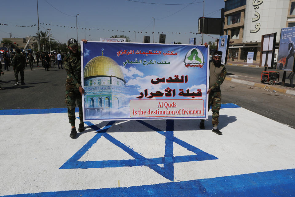 Iraqi Popular Mobilization Forces march over a representation of an Israeli flag during "al-Quds" Day, Arabic for Jerusalem, in Baghdad, Iraq, Friday, May 31, 2019. Jerusalem Day began after the 1979 Islamic Revolution in Iran, when the Ayatollah Khomeini declared the last Friday of the Muslim holy month of Ramadan a day to demonstrate the importance of Jerusalem to Muslims. (AP Photo/Khalid Mohammed)