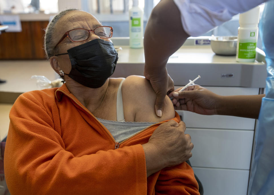 Thoko Hlongwane, receives the first dose of Pfizer COVID-19 vaccine from a health staff member during a vaccination day at a vaccination centre at Chris Hani Baragwanath Academic Hospital in Soweto, South Africa, Monday, May 17, 2021. South Africa has started its mass vaccination drive with the goal of inoculating nearly 5 million citizens aged 60 and above by the end of June. (AP Photo/Themba Hadebe)