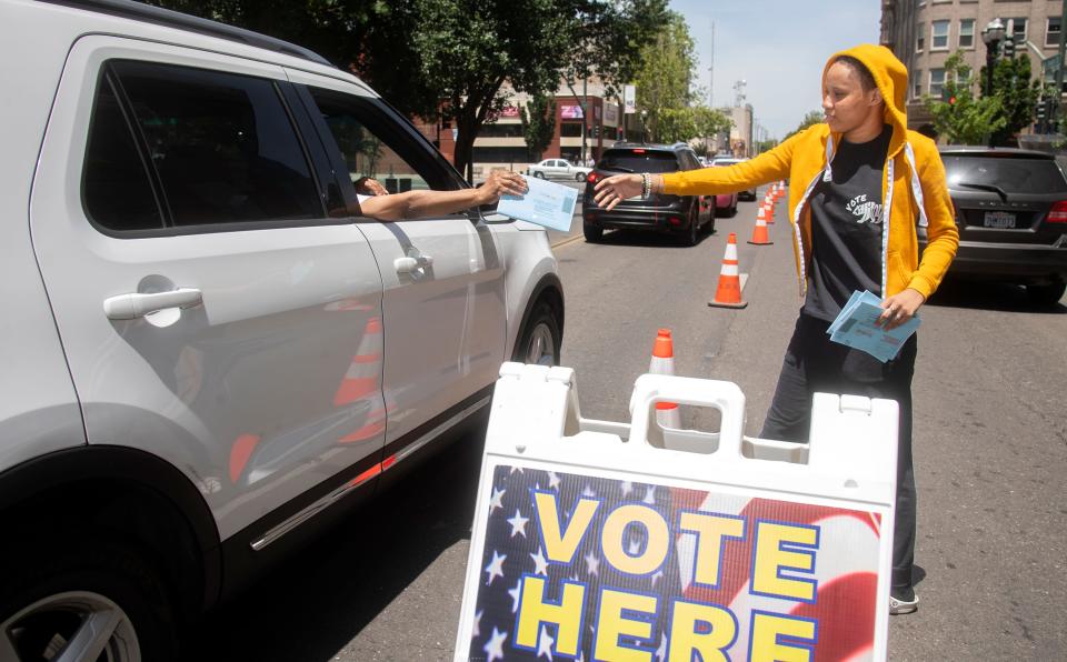 Election worker Kymra King accepts a ballot from a motorist at the drive-up ballot drop-off location outside of the San Joaquin County Administration Building on San Joaquin Street and Weber Avenue in downtown Stockton, on Primary Election Day, Tuesday, June 7, 2022. 