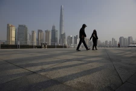 People walk in front of the financial district of Pudong in Shanghai, China, January 19, 2016. REUTERS/Aly Song