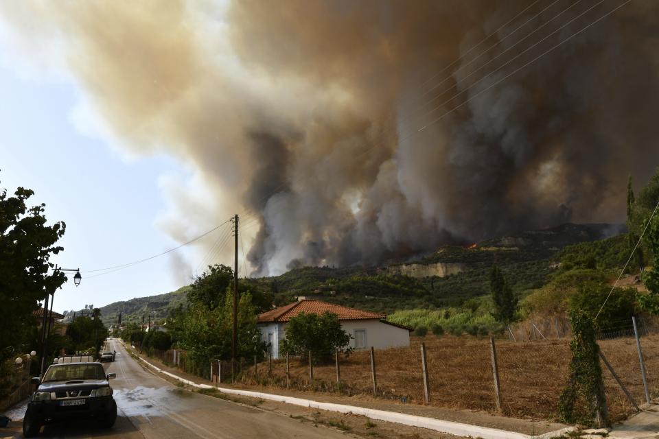 Flames burn a mountain over Pelopio village, near ancient Olympia, western Greece, Wednesday, Aug. 4, 2021. The European Union promised assistance Wednesday to Greece and other countries in southeast Europe grappling with huge wildfires after a blaze gutted or damaged more than 100 homes and businesses near Athens. (Giannis Spyrounis/ilialive.gr via AP)