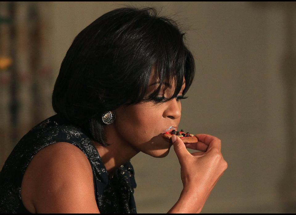 WASHINGTON, DC - DECEMBER 01:  First lady Michelle Obama takes a bite of a cookie she made while participating in an event at the White House on December 1, 2010 in Washington, DC. The first lady hosted the event to honor the military families who organize the Quantico and Anacostia branches of the Marine Corps Reserve annual Toys for Tots drive.  (Photo by Mark Wilson/Getty Images)