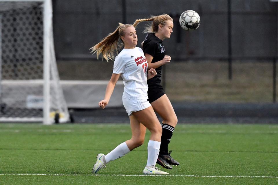 Assumption's Avery Roggenkamp (21) heads the ball away from Manual's Amelia Jones (17) during the championship game of the 7th Region girls soccer tournament, Saturday, Oct. 15, 2022 in Louisville Ky. Assumption defeated Manual 4-1.