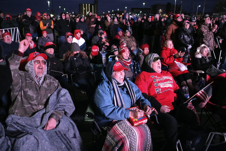 People watch a President Donald Trump campaign rally on a large screen television in parking lot outside the convention center in Wildwood, N.J., Tuesday, Jan. 28, 2020. (AP Photo/Seth Wenig)