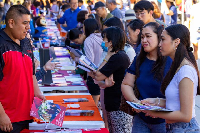 TEMPLE CITY, CA - OCTOBER 21: Pierre Gochuico, second from right, with her 15-year-old daughter Patricia Gochuico, gathers information at an annual college and career fair at Temple City High School on Saturday, Oct. 21, 2023 in Temple City, CA. (Irfan Khan / Los Angeles Times)