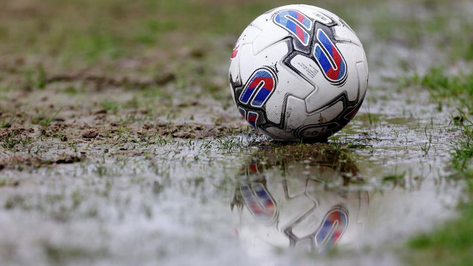 A football on a waterlogged pitch