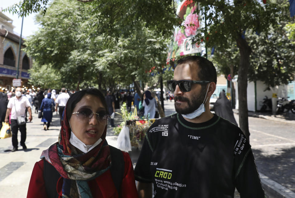 Fatemeh Rekabi, an accountant, speaks with The Associated Press about the upcoming presidential election, as she stands next to her friend Omid Alimardani, at the Grand Bazaar, in Tehran, Iran, Thursday, June 10, 2021. Consumed by fear of future economic decline, Rekabi, believes there’s no candidate worth voting for. (AP Photo/Vahid Salemi)