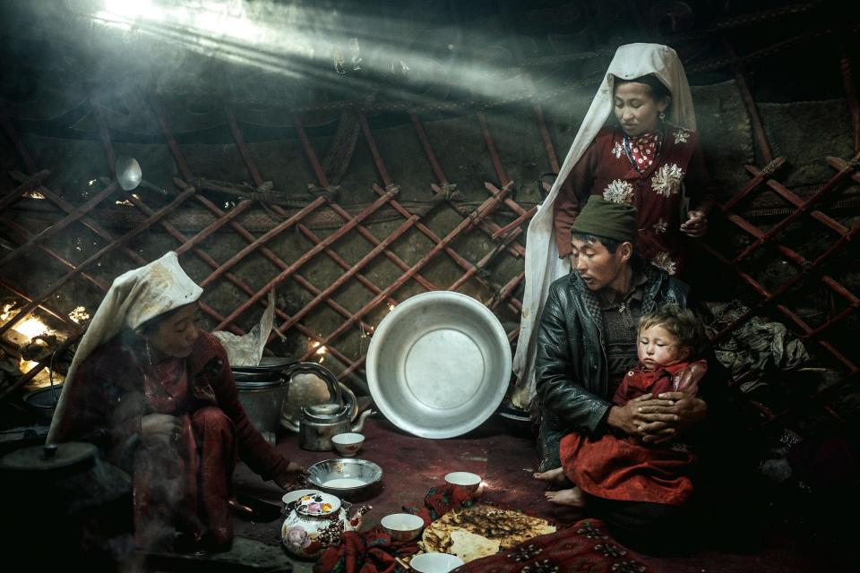 Two women, a man and a child, morning meal, yurt, a ray of light falls into it, nomadic Kyrgyz, Bozai Gumbaz, Wakhan corridor, Badakhshan, Afghanistan