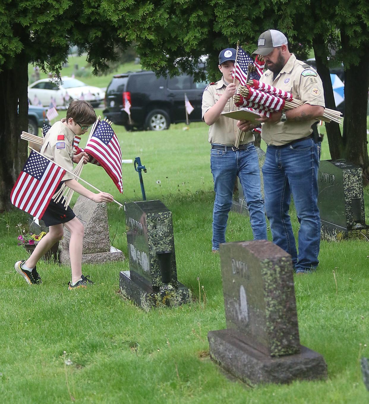 Scouts from Troop 86 place flags on Veterans graves at Dover Burial Park for Memorial Day.