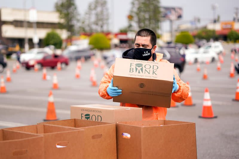 A volunteer with Los Angeles County Federation of Labor, AFL-CIO, hands out boxes of food to LAX workers in the parking lot of The Forum during the outbreak of the coronavirus disease (COVID-19), in Inglewood