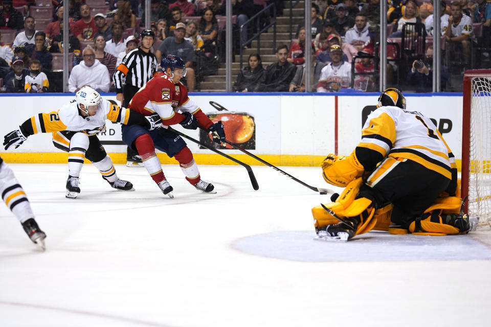 Florida Panthers defenseman Gustav Forsling (42) skates with the puck as Pittsburgh Penguins defenseman Chad Ruhwedel (2) defends during the second period of an NHL hockey game Thursday, Oct. 14, 2021, in Sunrise, Fla. (AP Photo/Lynne Sladky)