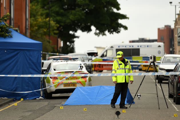 Police gather evidence near to forensics tents and evidence markers inside a cordon on Irving Street.