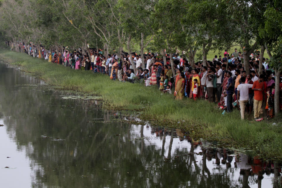 Supporters of India's ruling Bharatiya Janata Party (BJP) who could not enter the venue of an election rally addressed by Indian Prime Minister Narendra Modi, watch from a distance in Mathurapur, south of Kolkata, India, Thursday, May 16, 2019. (AP Photo/Bikas Das)