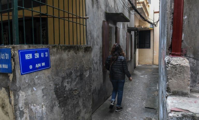 Nga walks toward the lane where her daughter was was molested in a residential quarter of Hanoi